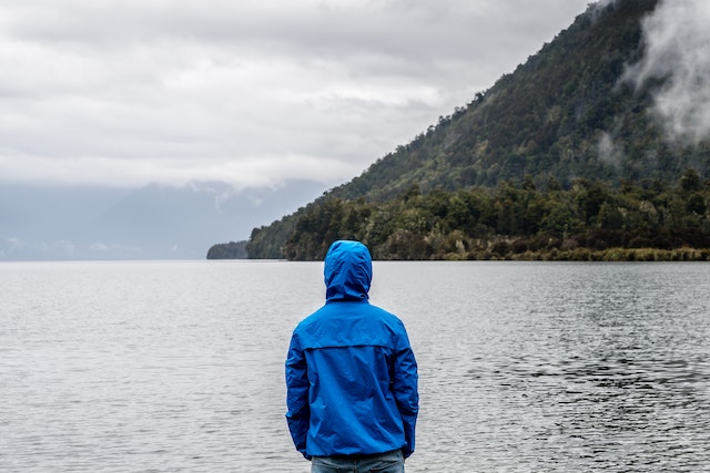 personne portant une veste bleu à la montagne